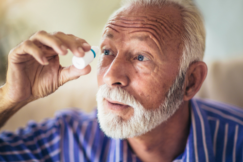 Older glaucoma patient using eye drops as treatment
