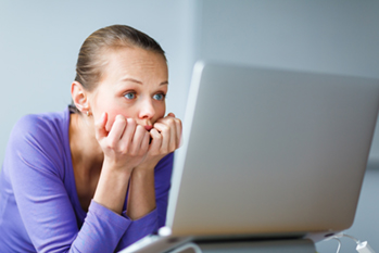 young girl looking closely at laptop monitor